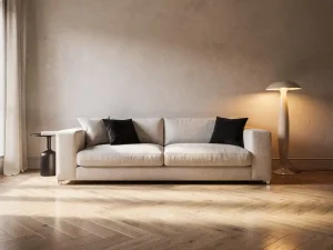 Elegante woonkamer met linnen bank van de muur geplaatst, visgraatparket, sculptuurlamp en natuurlijk middaglicht.