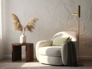 Italiaanse fauteuil in ivoren linnen naast een vloerlamp, met pampasgras in keramische vaas op walnoten bijzettafel in warm interieur.