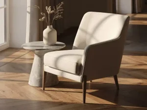 Linnen fauteuil in warm ivoor naast marmeren bijzettafel op eiken visgraatparket, met keramische vaas en middaglicht.