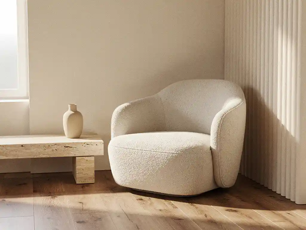 Sculpturele bouclé fauteuil naast een geribbelde gipswand met travertijn bijzettafel en keramische vaas in warm ivoor en salie interieur.