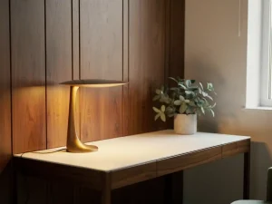 Vloer-tot-plafond walnoten opbergwand met minimalistisch bureau, designerlamp en klein potplantje in stijlvol thuiskantoor.